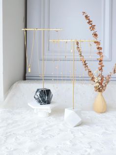 two vases with flowers in them sitting on a white surface next to each other