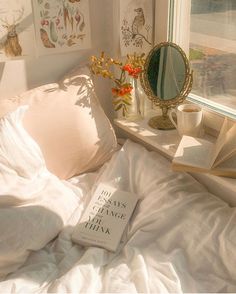 there is a book on the bed with white sheets