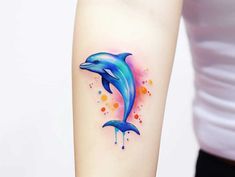 a woman's arm with a dolphin tattoo on the left side of her body