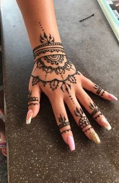 a woman's hand with henna tattoos on it