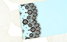 a piece of paper with an image of a lace pattern on it and a blue background