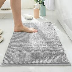 a person standing on top of a bathroom rug