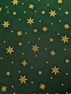 green and gold snowflakes are scattered on the ground in this pattern, which looks like they have been made out of wool