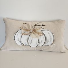 a decorative pillow with a white pumpkin on it