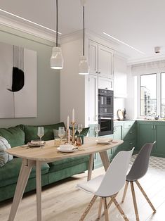 a living room filled with furniture and a green couch in front of a kitchen counter