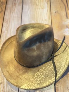 This unique vintage fedora hat, crafted from Australian wool, features an eye-catching design that includes a braided rope band and an embossed crocodile pattern on the brim. The hat is marked with the Woolmark logo inside, indicating it is made of pure new wool. The exterior showcases a worn, rustic charm, characteristic of a well-loved hat with a rich history. The brim's distinctive crocodile pattern adds a touch of rugged elegance, making this hat a standout piece for collectors and fashion enthusiasts alike. It appears to be from the mid-20th century, a time when such bold designs were popular in outdoor and casual attire. **Condition The hat shows signs of wear consistent with its age, including some fading and minor creases, which only enhance its vintage appeal. The interior is clea Wool Fedora Hat, Wool Fedora, Fedora Hat, Rustic Charm, Unique Vintage, Fedora, Caps Hats, Accessories Hats, Art Collection