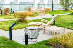 an empty lawn with two lounge chairs and a trash can