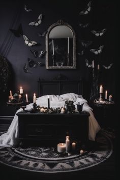 a bed with lots of candles on top of it in front of a mirror and butterflies