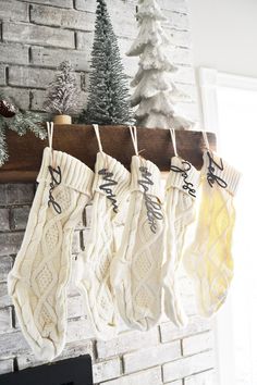 stockings hanging from a fireplace with christmas decorations