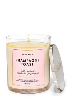 white barn champagne toast candle in a glass container with a pink label on the lid