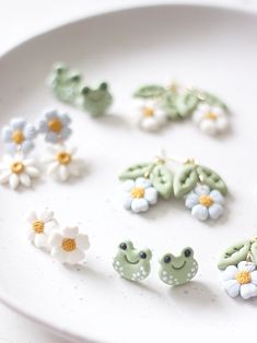 there are many earrings on the plate and one is made out of plastic flowers,