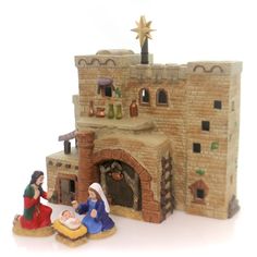 a nativity scene with figurines in front of a brick fireplace and door