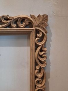 an ornate wooden frame hanging on the wall