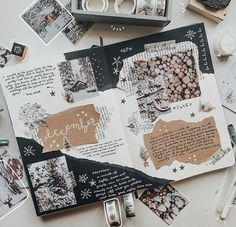 an open scrapbook with christmas cards and other items surrounding it on top of a table