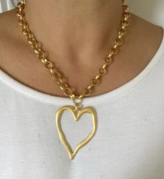 A really striking, oversized matte gold heart necklace featuring a statement hollow heart pendant on a chunky plated chain. This is a great piece for adding the wow factor to an everyday outfit. Despite being sizeable, it is very lightweight and comfortable to wear and looks awesome with an open neckline. ▪️22 Karat gold plated brass ▪️Heart - gold plated brass 62mm x 50mm ▪️Choose an oval link or belcher chain ▪️The necklace will be presented in attractive Scraffs gift packaging ready to gift or keep Gold Chunky Heart-shaped Jewelry, Chunky Heart-shaped Gold Jewelry, Gold Heart Pendant Chain Necklace, Chunky Heart Shaped Gold Jewelry, Gold Open Heart Necklace For Party, Chunky Heart-shaped Gold Necklace, Gold Chunky Heart Necklace, Chunky Gold Heart Necklace, Chunky Gold Necklaces