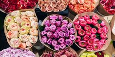 many different types of flowers are arranged in baskets on the table and ready to be sold