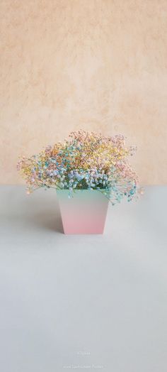 a pink vase filled with flowers on top of a table