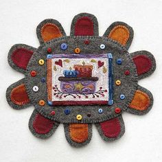 a decorative piece made out of felt with buttons on the center and an applique in the middle