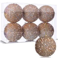 six christmas balls in a clear box with gold glittered decorations on the top and bottom