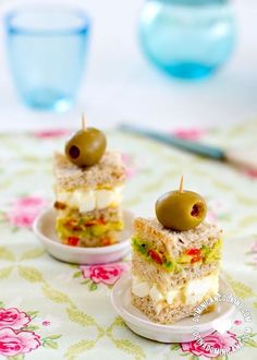 two small sandwiches with olives on them