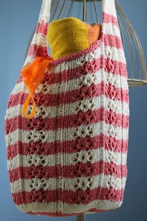 a red and white striped bag hanging on a rack with an orange object in it