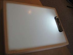 a white board sitting on top of a wooden table next to a remote control controller