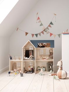 a doll house with lots of furniture and accessories on the floor in front of it