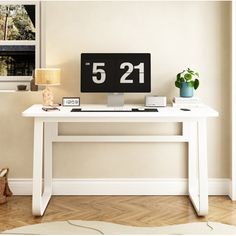 a white desk with a black clock on it and a lamp next to the table