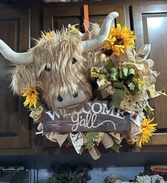 a cow head hanging from the side of a kitchen counter with sunflowers on it