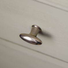 a close up of a door handle on a white cabinet