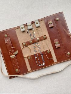 a brown leather case with beads and necklaces on it