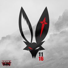 a black and red logo on top of a mountain in the foggy sky with mountains behind it