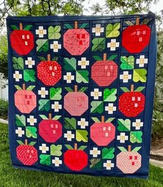 a quilted wall hanging on the side of a tree