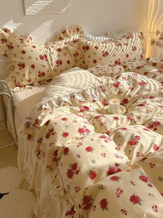 an unmade bed with floral sheets and pillows