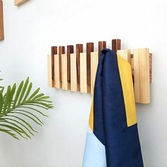 a blue and yellow towel hanging on a wall next to a potted palm tree