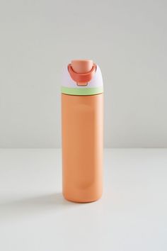 an orange and white insulated water bottle on a plain surface with no one around it