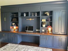 an office with built in cabinets and a rug on the floor, along with a large area rug