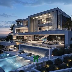 an aerial view of a modern house at dusk with pool and patio area in the foreground