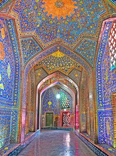 the inside of an ornate building with blue and red tiles on it's walls