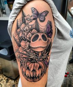 a skull with flowers and butterflies on it's head is shown in this tattoo design