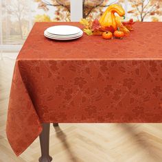 an orange table cloth with autumn leaves on it