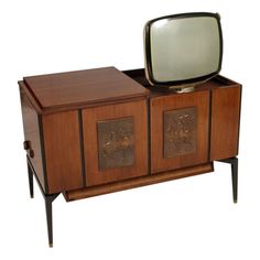 an old tv sitting on top of a wooden cabinet