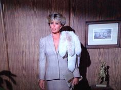 an older woman in a gray suit and fur stoler