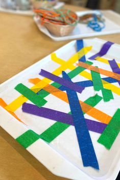 a paper plate that has some colored strips on it and is sitting on a table