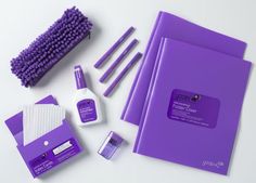 the contents of a purple notebook, pen, nail polish and other items are arranged on a white surface