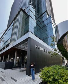 a woman taking a photo in front of a building with the words hybee inside