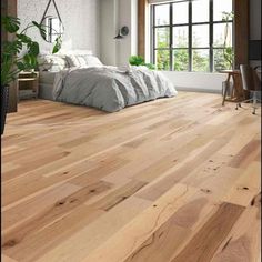 an empty bedroom with wood floors and white walls, large window overlooking the bed area