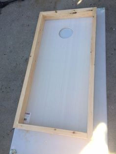 an unfinished piece of wood sitting on top of a white board with a hole in it