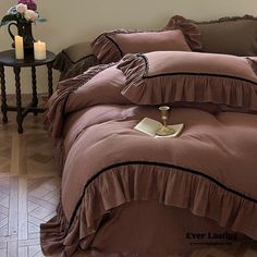 a bed with brown ruffled bedspread and two candles on the end table