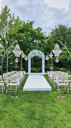 an outdoor ceremony setup with white chairs and blue flowers